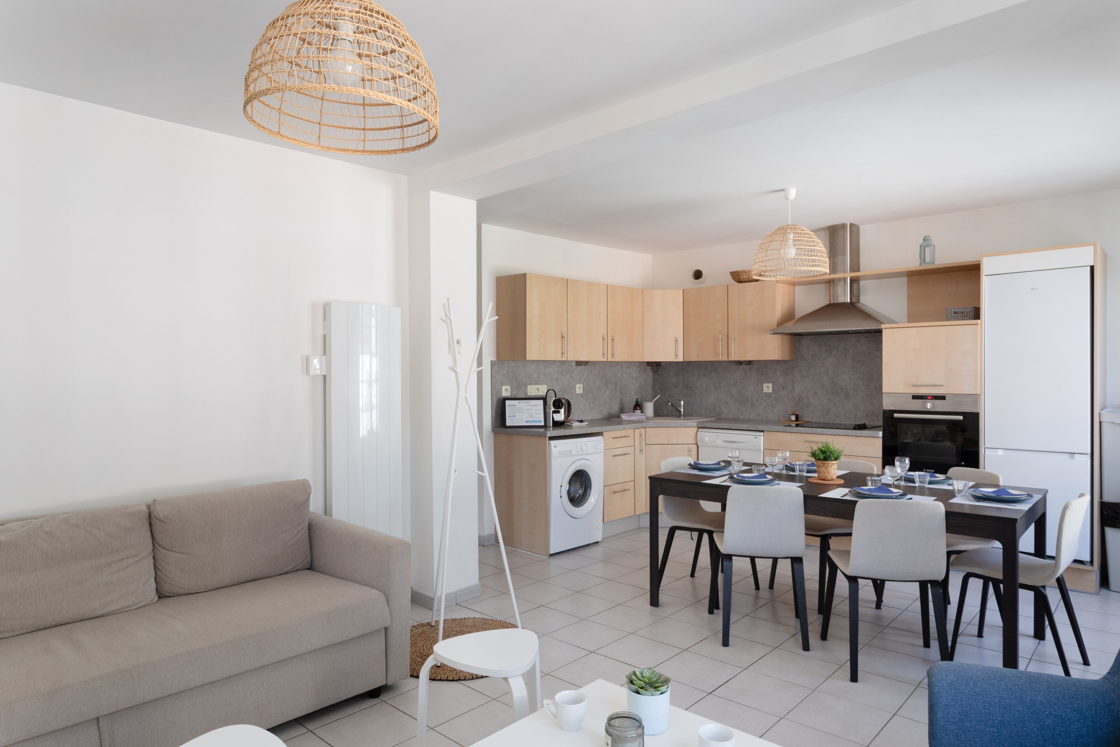 A modern apartment with a living room, kitchenette, and dining area.