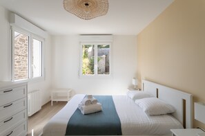 A bedroom with a bed, a window, a dresser, and a radiator. - Pieta - À moins de 100 m du port (Cancale)