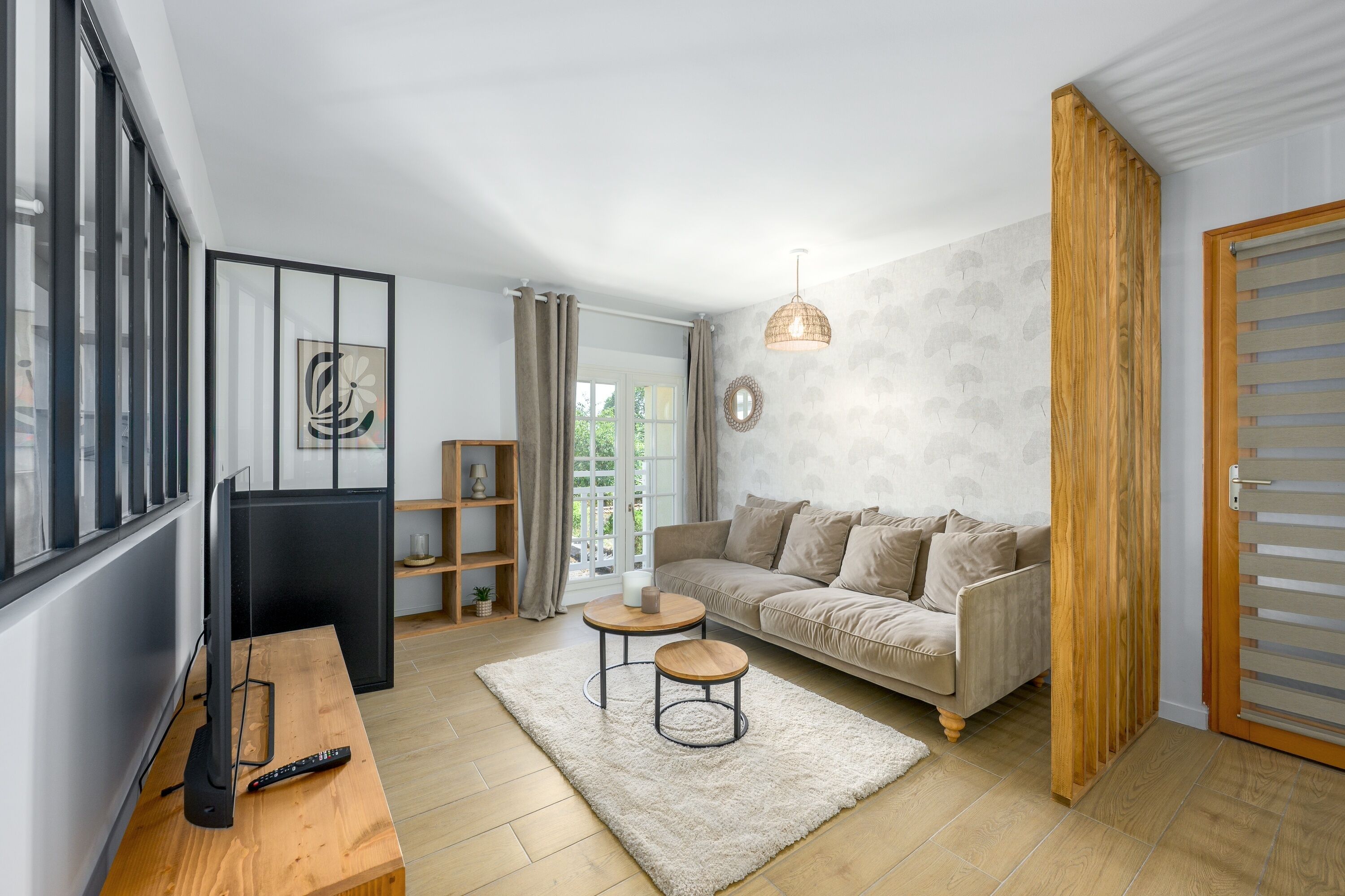 Un salon moderne avec un canapé, une table basse et un téléviseur.