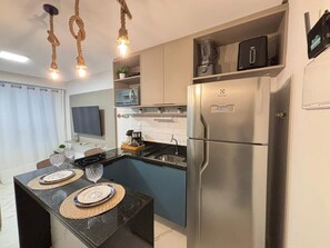Eine moderne Küche mit einem Edelstahlkühlschrank, einer Mikrowelle und einer Kaffeemaschine auf der Arbeitsfläche.