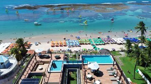 Ein Resort mit Poolbereich, Strand und klarem Wasser, inklusive Boote.