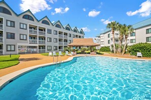 Un hôtel doté d’une piscine, de plusieurs balcons et d’un patio couvert.