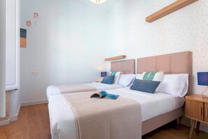 Een tweepersoonsbed met hoofdeinde, een nachtkastje en een wand met stermotief.