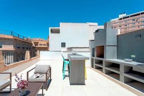 A rooftop terrace with a bar area, seating, and a view of the cityscape. - Genteel Home Casa de los 12 Balcones (Almeria)