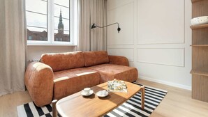 Un salon moderne avec un canapé marron, une table basse en bois et un tapis à rayures.