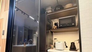 A modern kitchen with a built-in microwave, a coffee maker, and a blender on the countertop. - Flam Hotel Luxury Penthouse Osaka | Sauna & Rooftop Terrace Near USJ (大阪市)