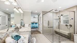 A modern bathroom with a glass-enclosed shower, a marble sink, and a large mirror. - 3 Bedroom/3.5 bath waterfront pool home with dock and lift (Marco Island)