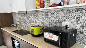 A kitchen with a microwave, a green appliance, and a tiled backsplash. - Maribel Villa Phu Quoc 4BR - Private Pool (Phú Quốc)
