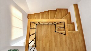 A wooden staircase with a handrail and a landing area.
