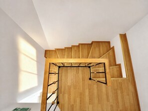 Una escalera de madera con barandilla y rellano.