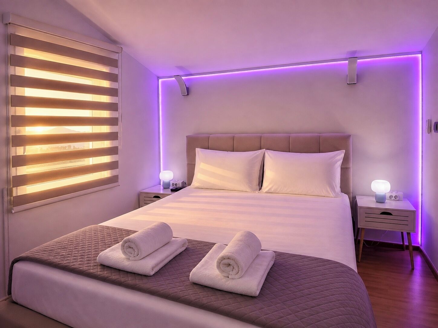 Una camera da letto moderna con un letto grande, due comodini e una finestra con persiane.