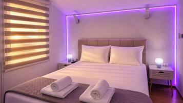 Una camera da letto moderna con un letto grande, due comodini e una finestra con persiane.