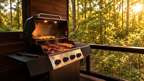 A barbecue grill with multiple cooking zones and a view of a forested area. - Secluded Cabin Perfect for Couples & Families with Hot Tub & Stone Fireplace in Broken Bow, Oklahoma (Broken Bow)