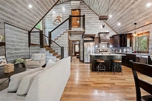 A spacious kitchen with a central island, wooden flooring, and a rustic ceiling. - Secluded Cabin Perfect for Couples & Families with Hot Tub & Stone Fireplace in Broken Bow, Oklahoma (Broken Bow)