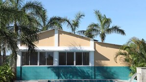 A modern building with a swimming pool, surrounded by palm trees. - Ocean Blue villa 2bhk (Cheyyur (Taluk) / Vadapattinam)