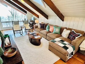 Un salon chaleureux avec un canapé marron, une table basse et un tapis à motifs.