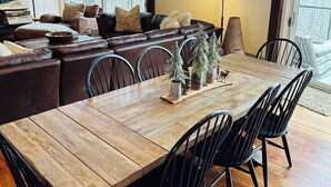 A dining area with a wooden table, black chairs, and a chandelier. - Luxury 4-bedroom Ski house in Stratton with Shuttle or Walk to Slope Options (Stratton)