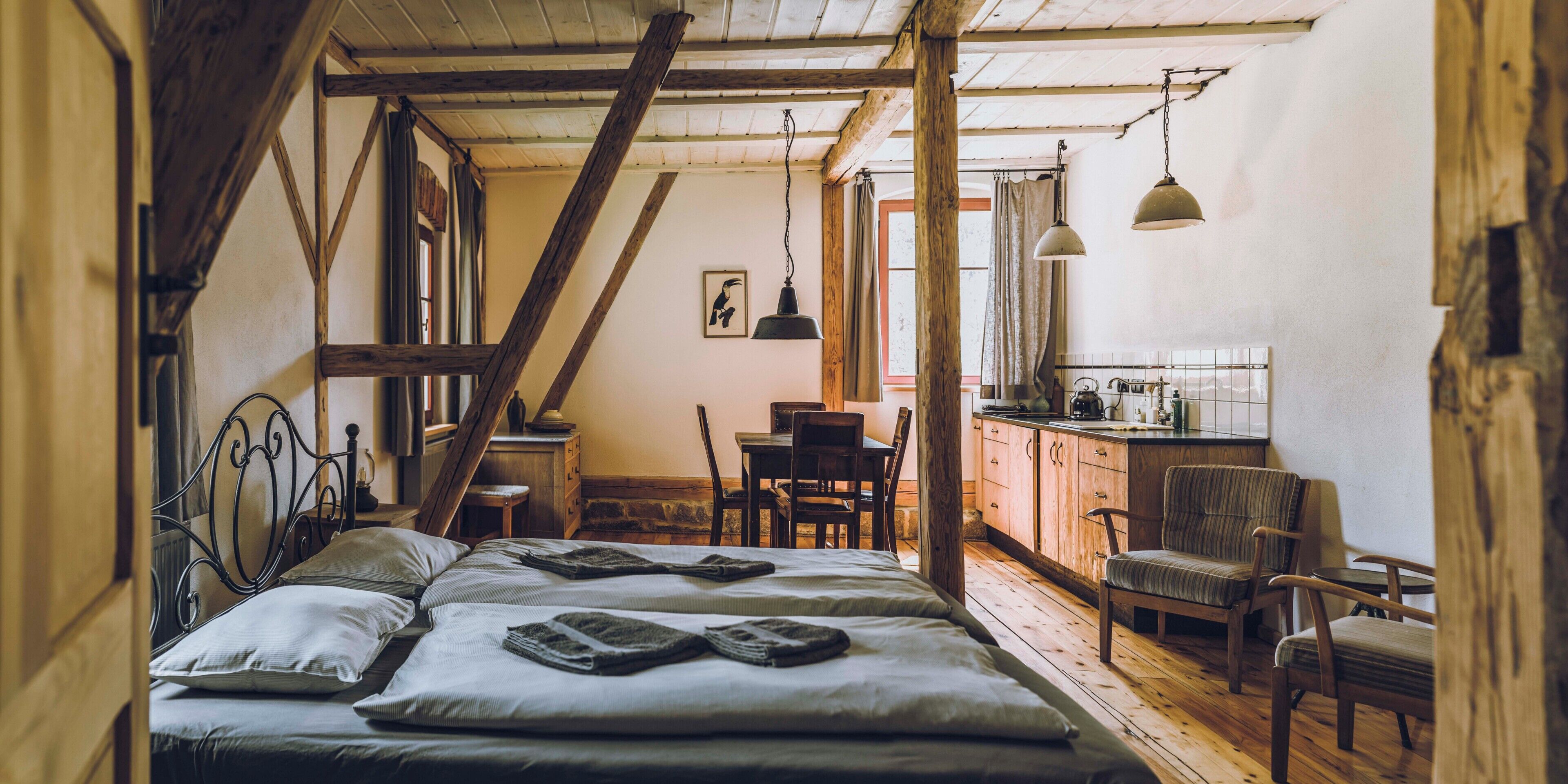 Une chambre confortable avec un plafond en bois, un lit avec des oreillers, une table de chevet et une fenêtre.