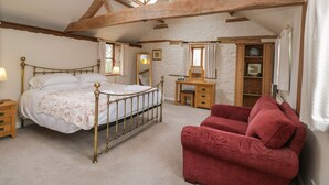 Ein Schlafzimmer mit Bett, Schreibtisch, Stuhl und Kleiderschrank.