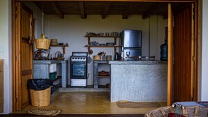A compact kitchen with wooden beams, a built-in oven, and a refrigerator.