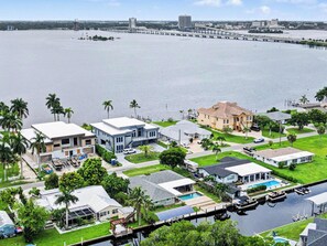 Um bairro residencial com casas, um cais e uma ponte ao fundo.