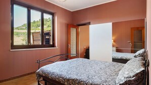 Un dormitorio con una cama, una ventana y una puerta.