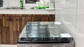 A kitchen with a stainless steel stove, a window with blinds, a dish rack, and a faucet. - A chic and cozy apartment in the heart of Cotonou (Cotonou)