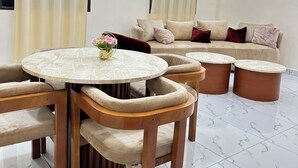 A modern living room with a round marble table, beige sofas, and a ceiling fan. - A chic and cozy apartment in the heart of Cotonou (Cotonou)