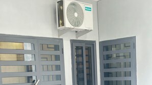 A room with two grey doors, a window, and an air conditioning unit mounted on the wall. - A chic and cozy apartment in the heart of Cotonou (Cotonou)
