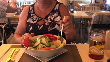 Comedor con mesas, sillas y un atril para el menú.