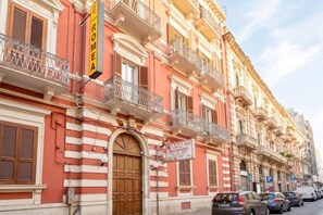 A building with a prominent 'ROMEA' sign, a large wooden door, and multiple balconies with metal railings. - City Hub 1 | Boutique Studio in Bari's Historic Heart (Bari)