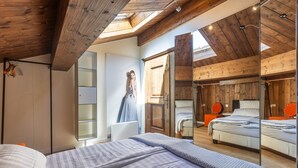 A bedroom with a large bed, a wardrobe, a mirror, and a skylight. - Apartment "Weiser Hirsch" in Chalet Burgblick with Castle Views and Modern Comfort (Weilrod)