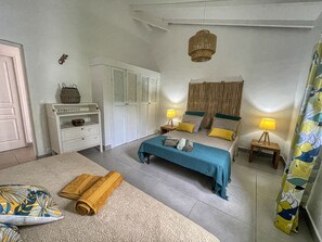 Een slaapkamer met een bed, nachtkastjes, een kledingkast en een hanglamp.