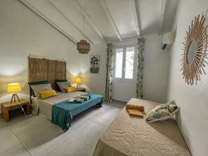 Ein Schlafzimmer mit einem Bett, Nachttischen, einem Fenster und einem Wandbild.