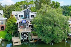 A house with a dock extending into a body of water, surrounded by trees. - "Catican Bayou" Fish River Waterfront Home 3 bedrooms; 5 bathrooms  Kayaks (Summerdale)