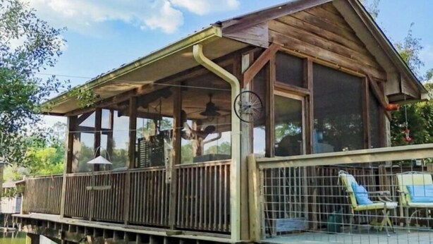 A wooden cabin with a balcony, a railing, and a small deck area. - "Catican Bayou" Fish River Waterfront Home 3 bedrooms; 5 bathrooms  Kayaks (Summerdale)