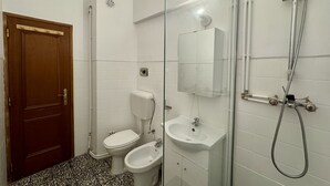 Un baño con inodoro, lavabo, ducha y bidé.