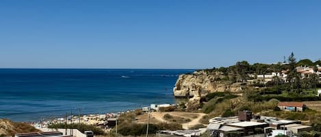 Una zona costiera con parcheggio, spiaggia e edifici.