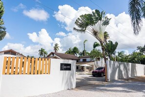 Una entrada protegida por una reja a una propiedad, con un letrero que dice 'Solaris Villa'.