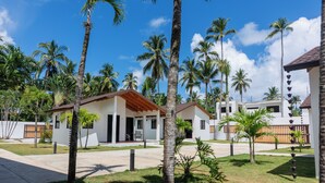 Um resort com vários edifícios, palmeiras e um céu azul límpido.