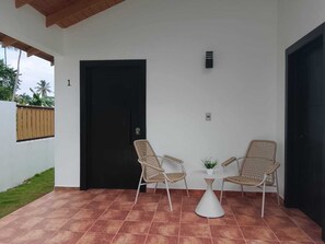 A covered patio area with two wicker chairs, a small table, and a potted plant. - Charming 1-bedroom bungalow with AC in Las Terrenas (Las Terrenas)