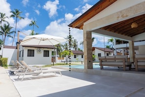 Ein Resort mit Pool, Liegestühlen und einer überdachten Sitzgelegenheit.