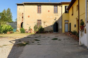 A building with a courtyard, a door, and a window.