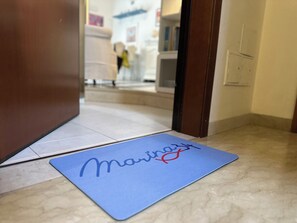 A blue mat with a name on a hotel entrance. - BeHappyM • Fair/St. Ursula • Skyview (Bologna)