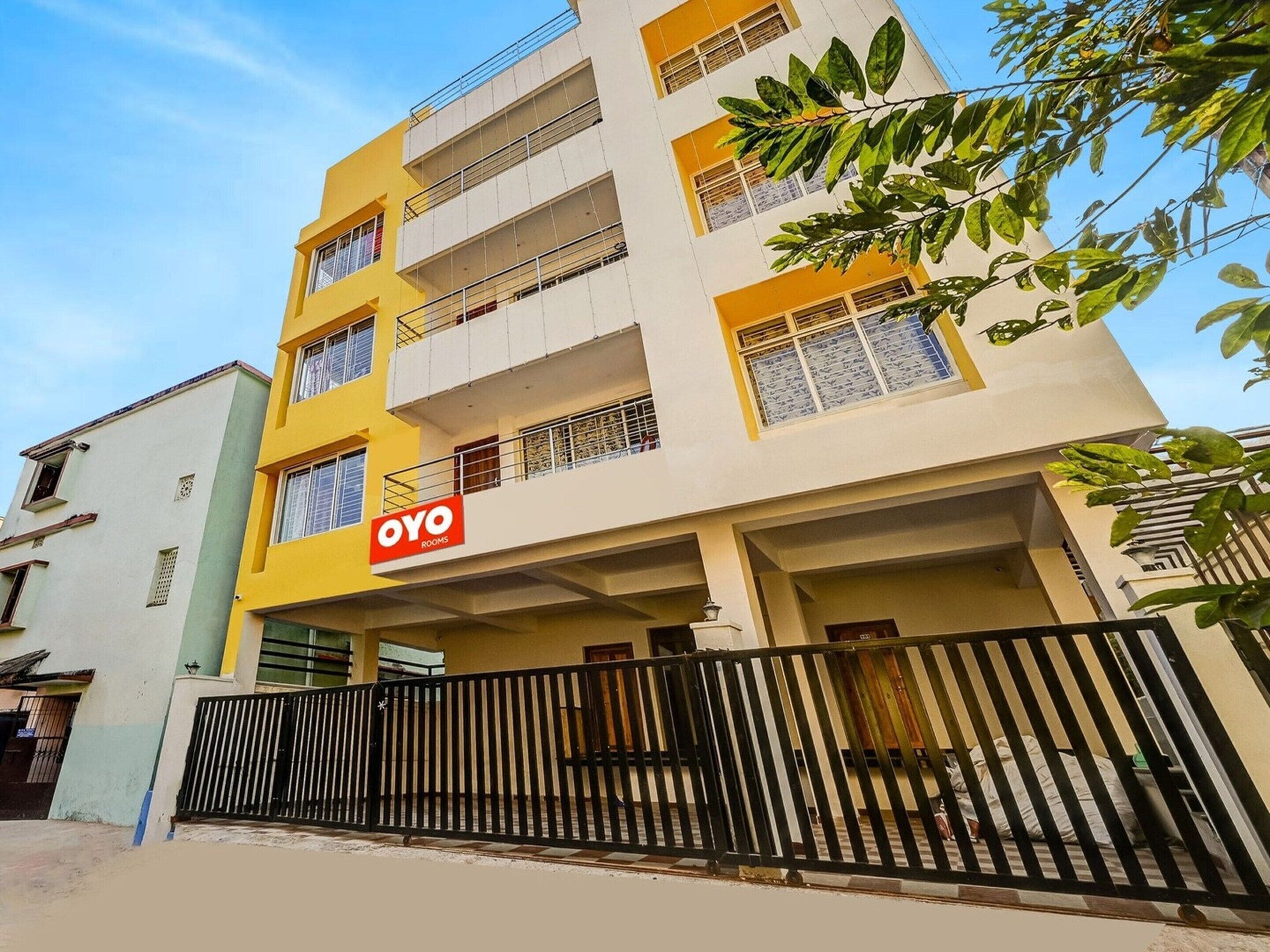 Een meerlaags gebouw met een bord waarop 'OYO ROOMS' staat, wat duidt op een hotel of verblijfsoord.