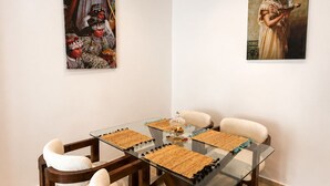 A dining area with a glass table, woven placemats, and cushioned chairs. - Family Apartment for 4–5 People (Fes)