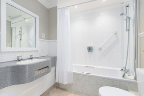 Une salle de bain moderne avec deux vasques, une baignoire et une douche.