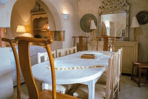 A dining area with a round table, chairs, and a mirror above.