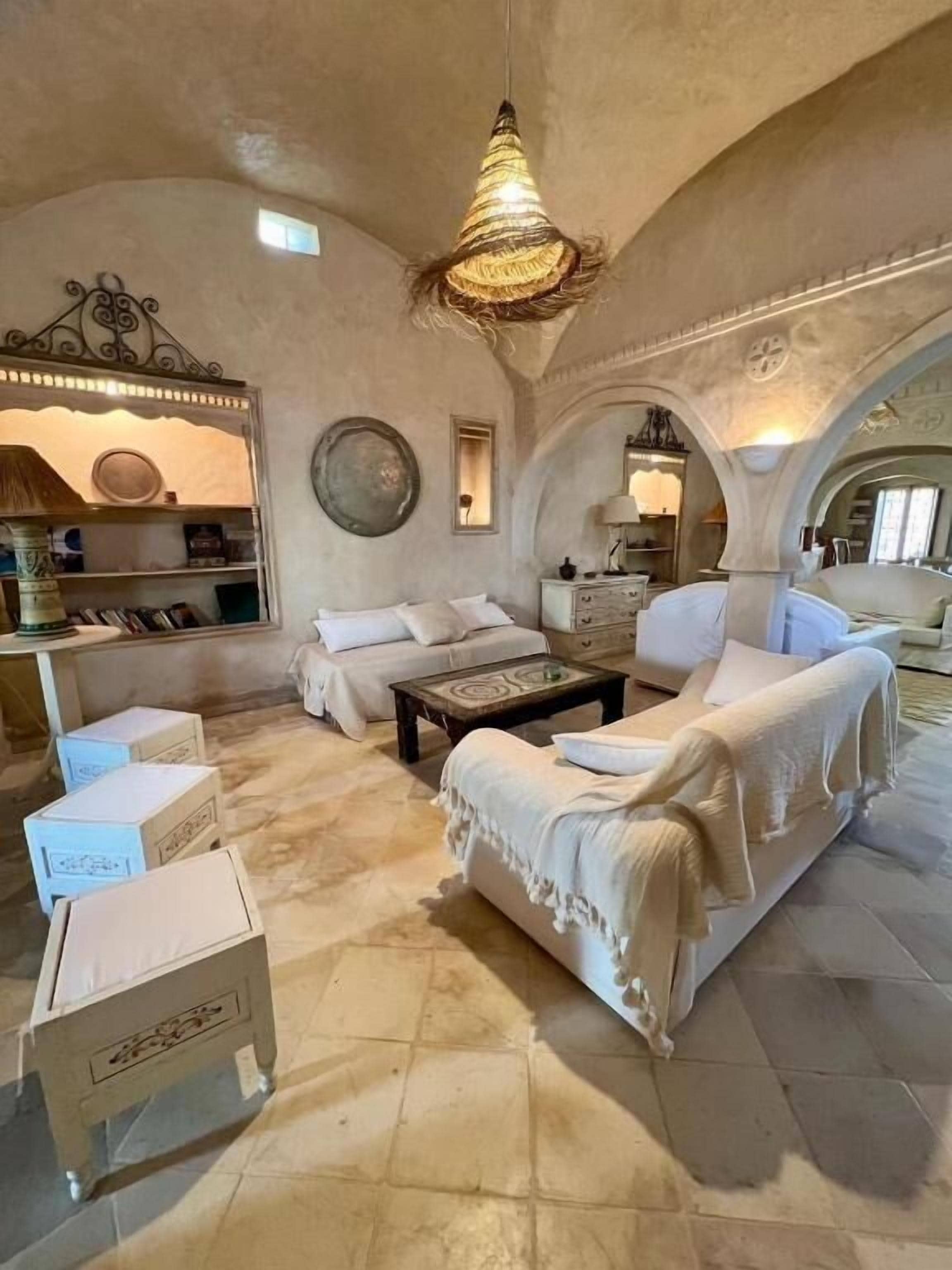 A spacious living room with a high ceiling, a central coffee table, and a sofa set.