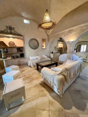 A spacious living room with a high ceiling, a central coffee table, and a sofa set.